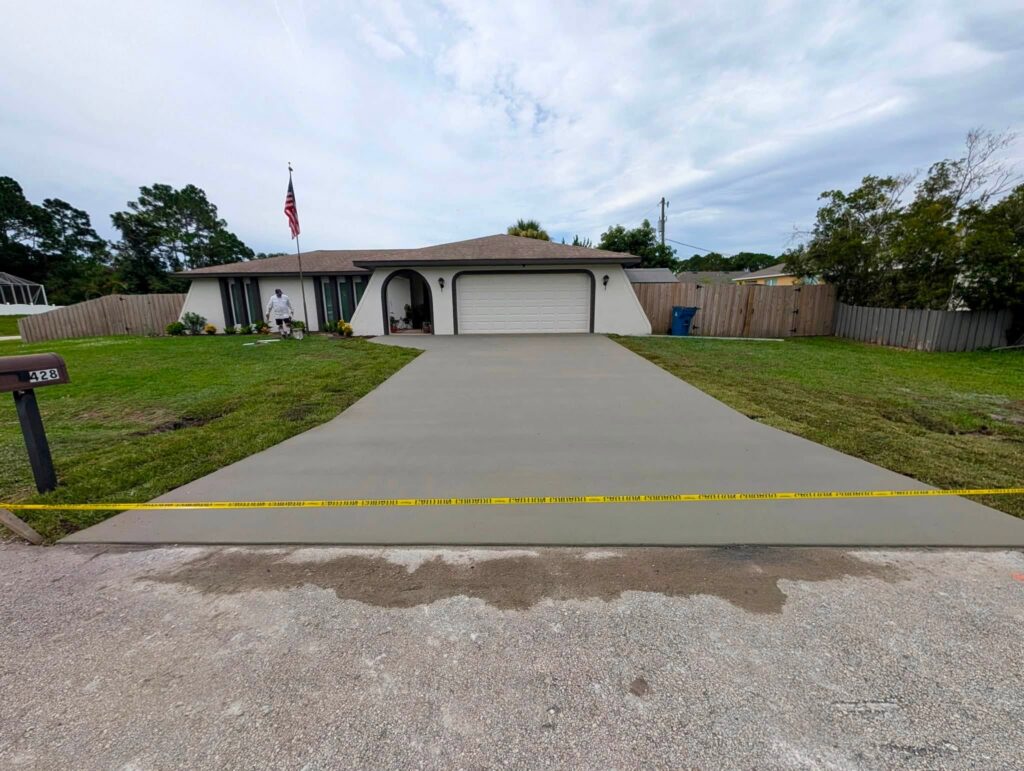 Residential concrete driveway with caution tape across the entrance