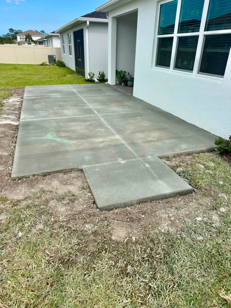 Finished concrete slab and walkway beside a residence.