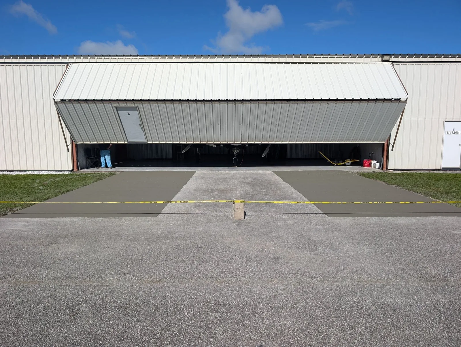 Wide concrete access aprons installed at a commercial metal building by JCD Concrete