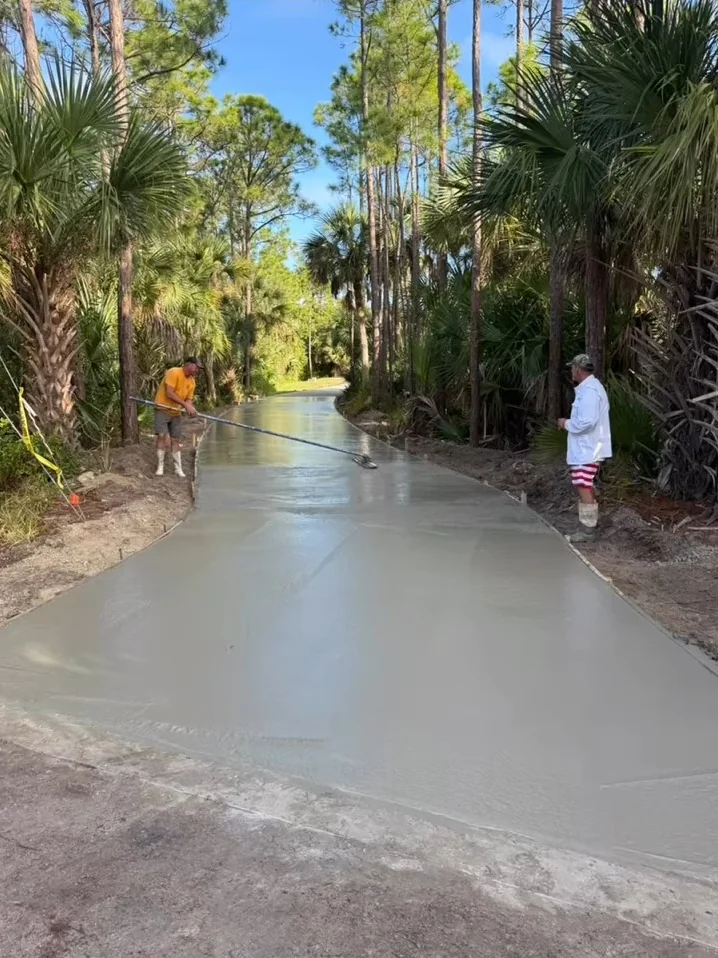 JCD crew finishing a concrete driveway through a wooded property