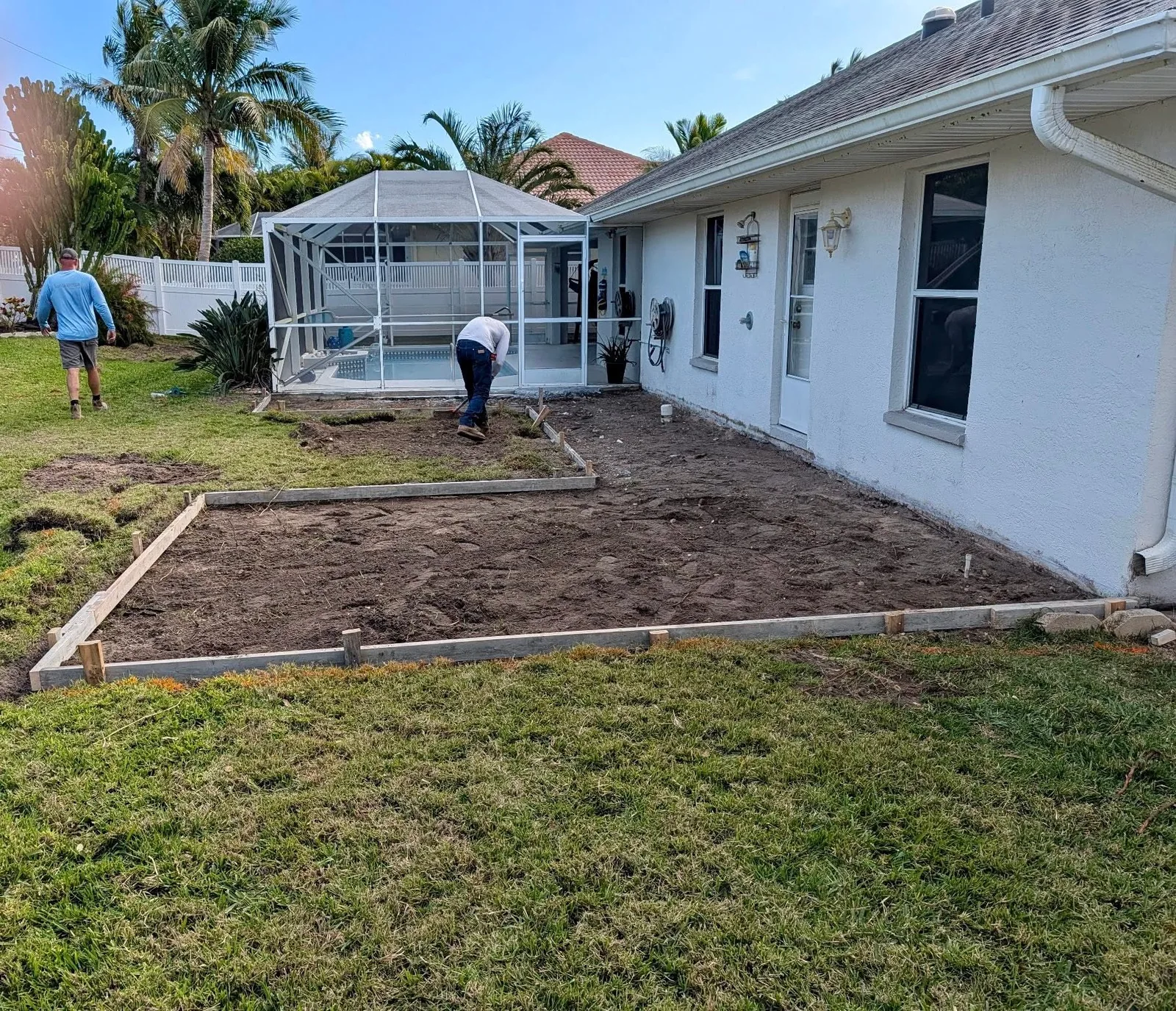 Preparing and grading a backyard area for a new concrete patio