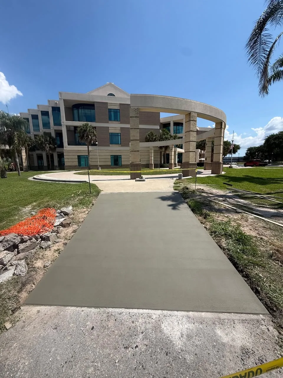 Completed concrete sidewalk leading to a campus building by JCD Concrete