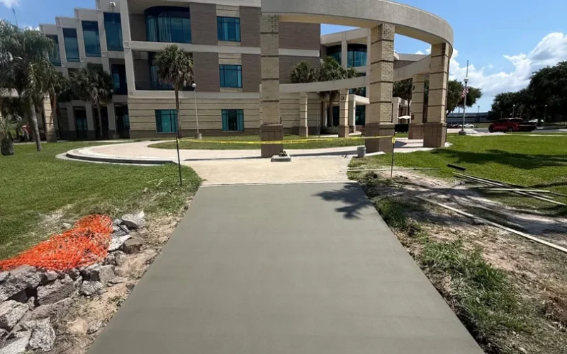 New concrete walkway leading toward a large building